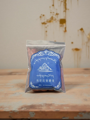 Tibetische Räucherstäbchen in blauer Verpackung auf einem Holztisch, ideal für Meditation und Yoga.